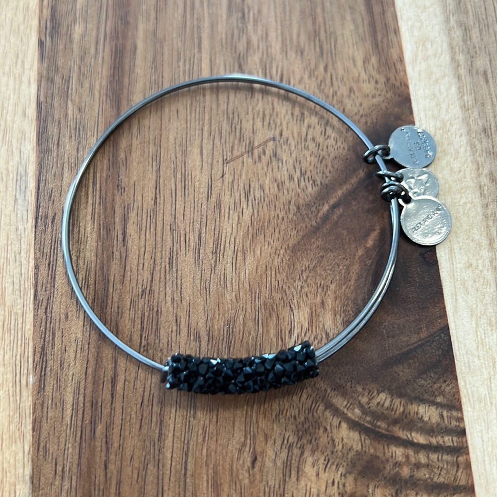 Alex and Ani dark, shiny silver adjustable bracelet with black, sparkly stones.